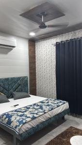 a bedroom with a bed and a ceiling fan at Hotel Dhamija divine inn in Sirsa