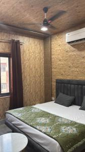 a bedroom with a bed and a ceiling fan at Hotel Dhamija divine inn in Sirsa