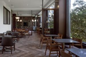 a restaurant with tables and chairs and windows at Toronto Airport Marriott Hotel in Toronto