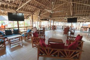 a room with chairs and tables and televisions in a building at Villa Dahl Beach Resort in Dar es Salaam