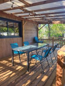 a patio with a table and chairs on a deck at Camping LES ARBOUSIERS Carcans in Carcans