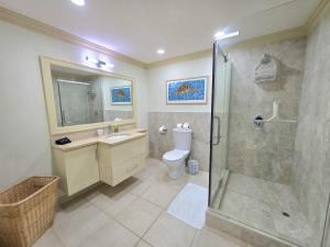 a bathroom with a shower and a sink and a toilet at Mistle Cove 102 in Christ Church +19 photos