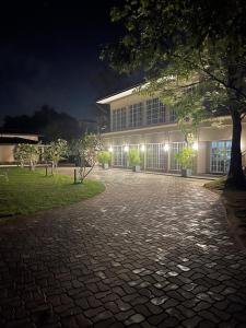 a building lit up at night with a brick driveway at The palace lanka in Yakwala