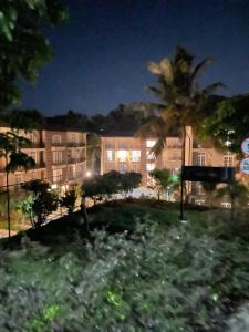 a large apartment building at night with a palm tree at The palace lanka in Yakwala