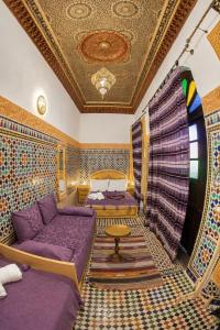 a room with a couch and a bed and a ceiling at Riad Chada Fez in Fez