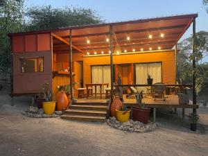 a small house with a table and some plants at Terracotta River Hideaway in Maun