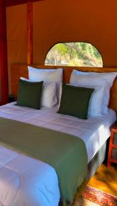 a bed with green and white pillows in a room at Terracotta River Hideaway in Maun +12 photos