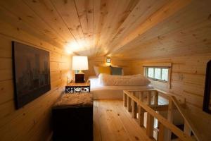 a bedroom with a bed in a wooden cabin at Casa Rosa Unit C on Lake Conroe in Willis