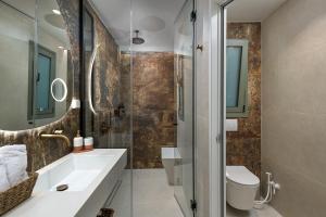 a bathroom with a sink and a toilet and a shower at Sirin Luxury Suites Groundfloor in Haraki +31 photos
