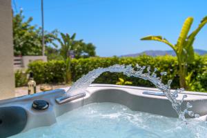 a fountain in a pool with water coming out at Sirin Luxury Suites Groundfloor in Haraki