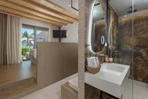 a bathroom with a sink and a glass shower at Sirin Luxury Suites Groundfloor in Haraki