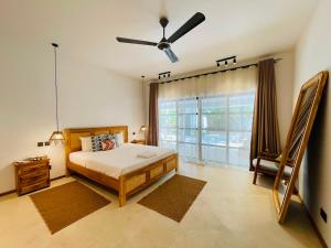 a bedroom with a bed and a ceiling fan at Solymar Villa 3 in Jambiani