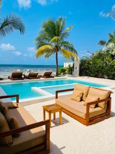 a resort with a pool and a bed and a couch at Solymar Villa 3 in Jambiani