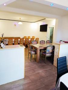 a dining room with a table and chairs at Vila Vali in Şuncuiuş