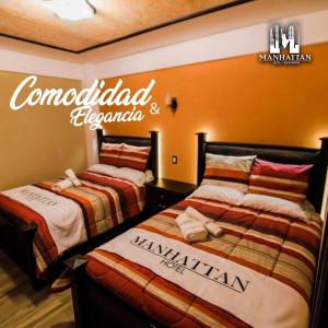 two beds sitting next to each other in a room at Hotel y Restaurante Manhattan in La Tenería