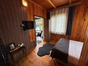 a bedroom with a bed and a flat screen tv at Ayder Serender Otel in Çamlıhemşin