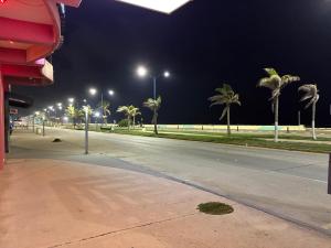 an empty street at night with palm trees and street lights at Hotelito Fiesta Caribena in Coatzacoalcos +12 photos
