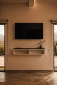 a living room with a flat screen tv on a wall at Sed de Valle-Valle de Guadalupe in Ensenada
