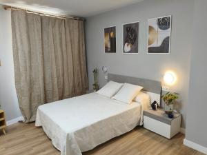 a bedroom with a white bed and a window at A un paso de Laurel Estudio con balcón in Logroño