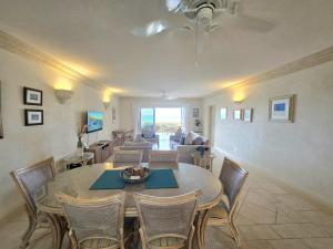 a dining room and living room with a table and chairs at Mistle Cove 102 in Christ Church
