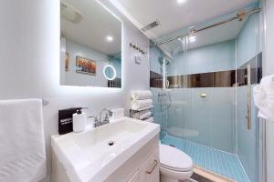 a bathroom with a sink and a glass shower at New & Modern Basement Suite - St Clair Hotel in Toronto