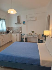 a bedroom with a blue bed and a kitchen at Phoenix in Fira
