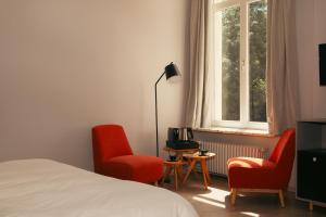 a bedroom with two chairs and a bed and a window at B&B Inn Between in Ghent