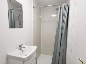 a white bathroom with a sink and a shower at Historic Loft in Cork in Cork