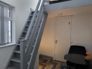 a staircase in a room with a table and a chair at Historic Loft in Cork in Cork