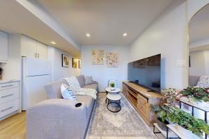 a living room with a couch and a tv at New & Modern Basement Suite - St Clair Hotel in Toronto