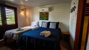 a bedroom with two beds with towels on them at Icarai Kite House in Icaraí