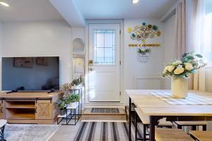 a dining room with a table with a vase of flowers at New & Modern Basement Suite - St Clair Hotel in Toronto
