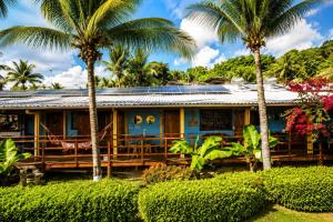 a house with palm trees in front of it at Pousada Mar Aberto in Fernando de Noronha