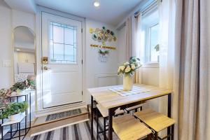 a dining room with a table and a vase of flowers at New & Modern Basement Suite - St Clair Hotel in Toronto +5 photos