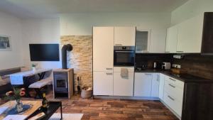 a kitchen with white cabinets and a counter top at Auszeitplatzl in Unken