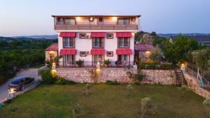 a large house with a car parked in front of it at Satsuma Butik Otel in Seferihisar
