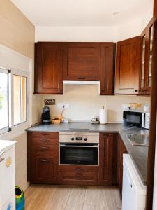 a kitchen with wooden cabinets and a stove top oven at Can Costals Cerezo in Pals