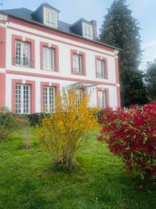 a large pink house with flowers in the yard at Juste le bruit des fleurs in Saint-Nicolas-de-Sommaire