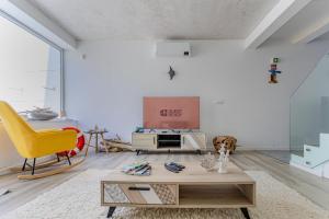 a living room with a table and a yellow chair at GuestReady - Tranquil Oasis in Lagoa in Lagoa