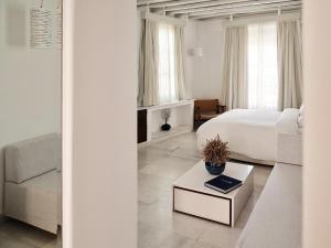 a white bedroom with a bed and a couch at Belvedere Mykonos - Main Hotel - The Leading Hotels of the World in Mikonos