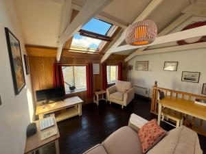 a living room with a couch and a tv at Abbey Place Net Loft in Mousehole