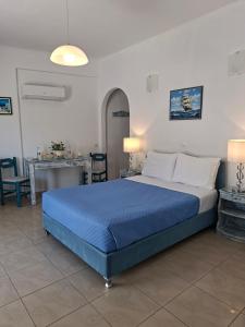 a bedroom with a blue bed and a table at Phoenix in Fira +62 photos