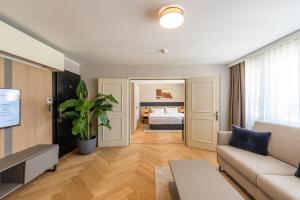a living room with a couch and a bed at Tailormade Hotel METROPOL St Gallen in St. Gallen +40 photos