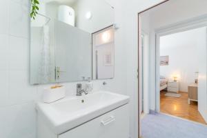 a white bathroom with a sink and a mirror at Guest house Bella in Slatine +44 photos