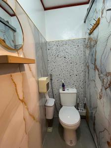 a small bathroom with a toilet and a mirror at Tiny house studio near SM City Daet in Daet