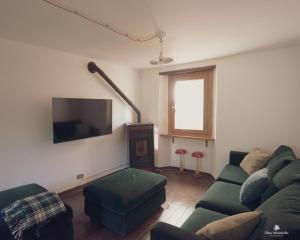 a living room with a couch and a flat screen tv at Casetta dalle finestre rosse in Bedonia