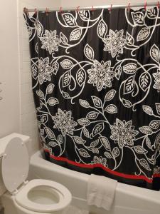 a bathroom with a black shower curtain with a toilet at Heritage Inn in Fairview