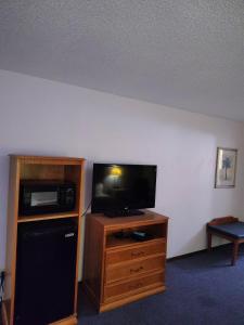 a room with a flat screen tv and a microwave at Heritage Inn in Fairview