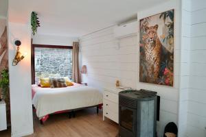 a bedroom with a bed and a picture of a tiger at Escapade tropicale au Costa Rica in Profondeville