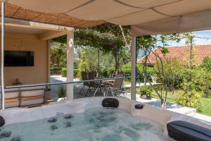 a jacuzzi tub in a backyard with a television at Guest house Bella in Slatine